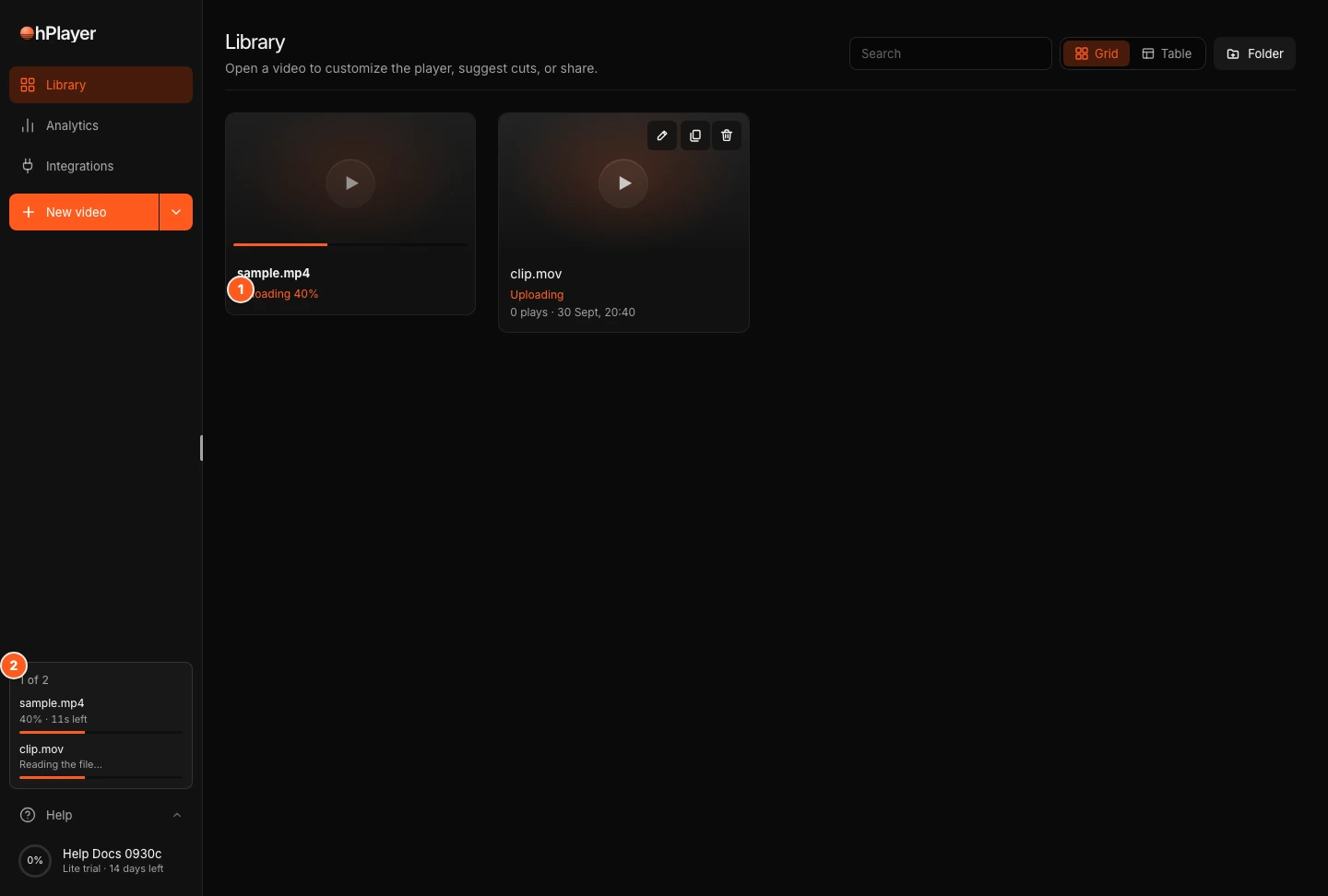 The Library with a video that is being prepared. Marker 1 points to the status chip on the video row, marker 2 to the upload tray at the bottom of the sidebar.